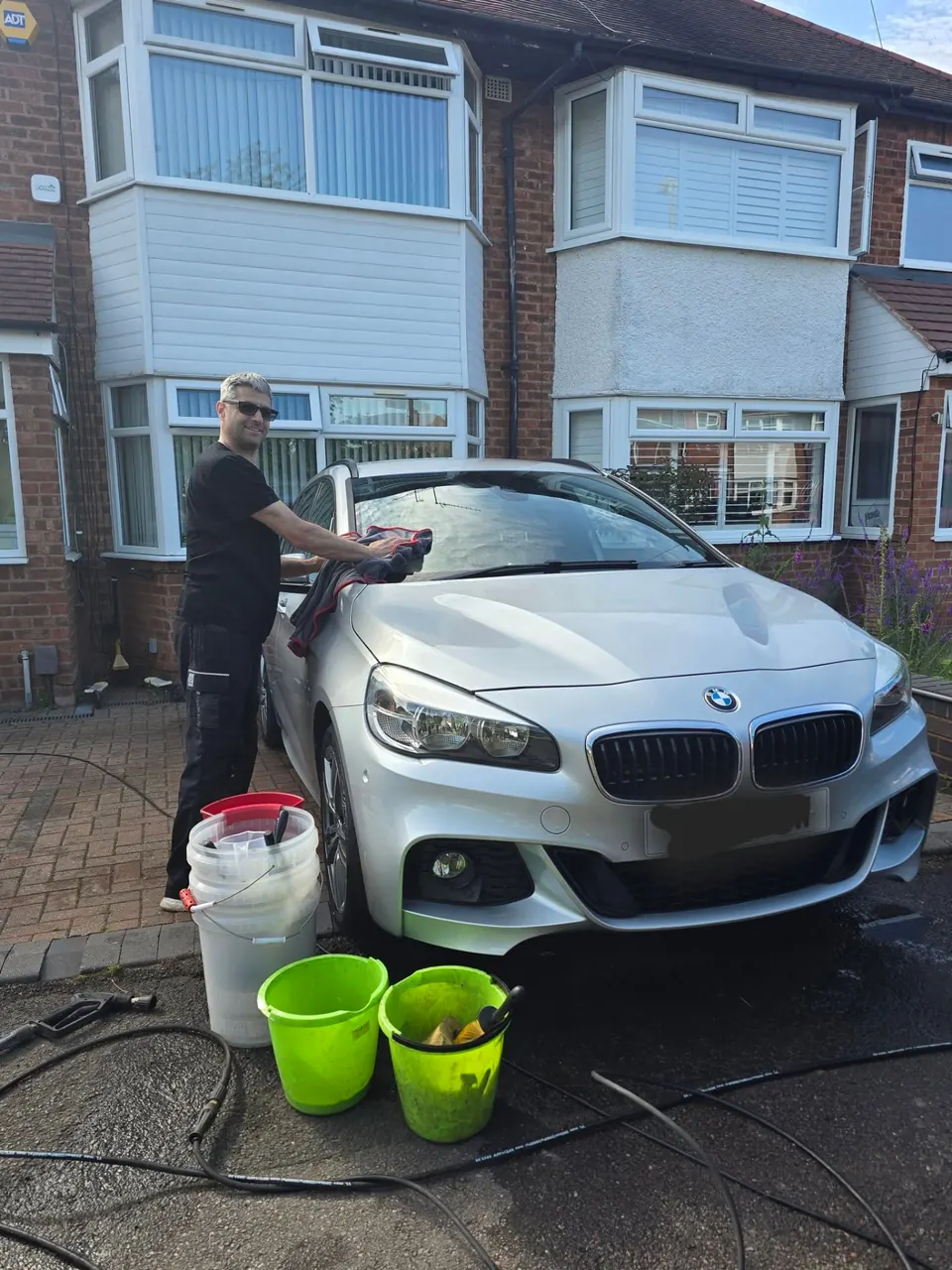 Riyaz drying the silver BMW 2 Series with a towel after its Sunday valet