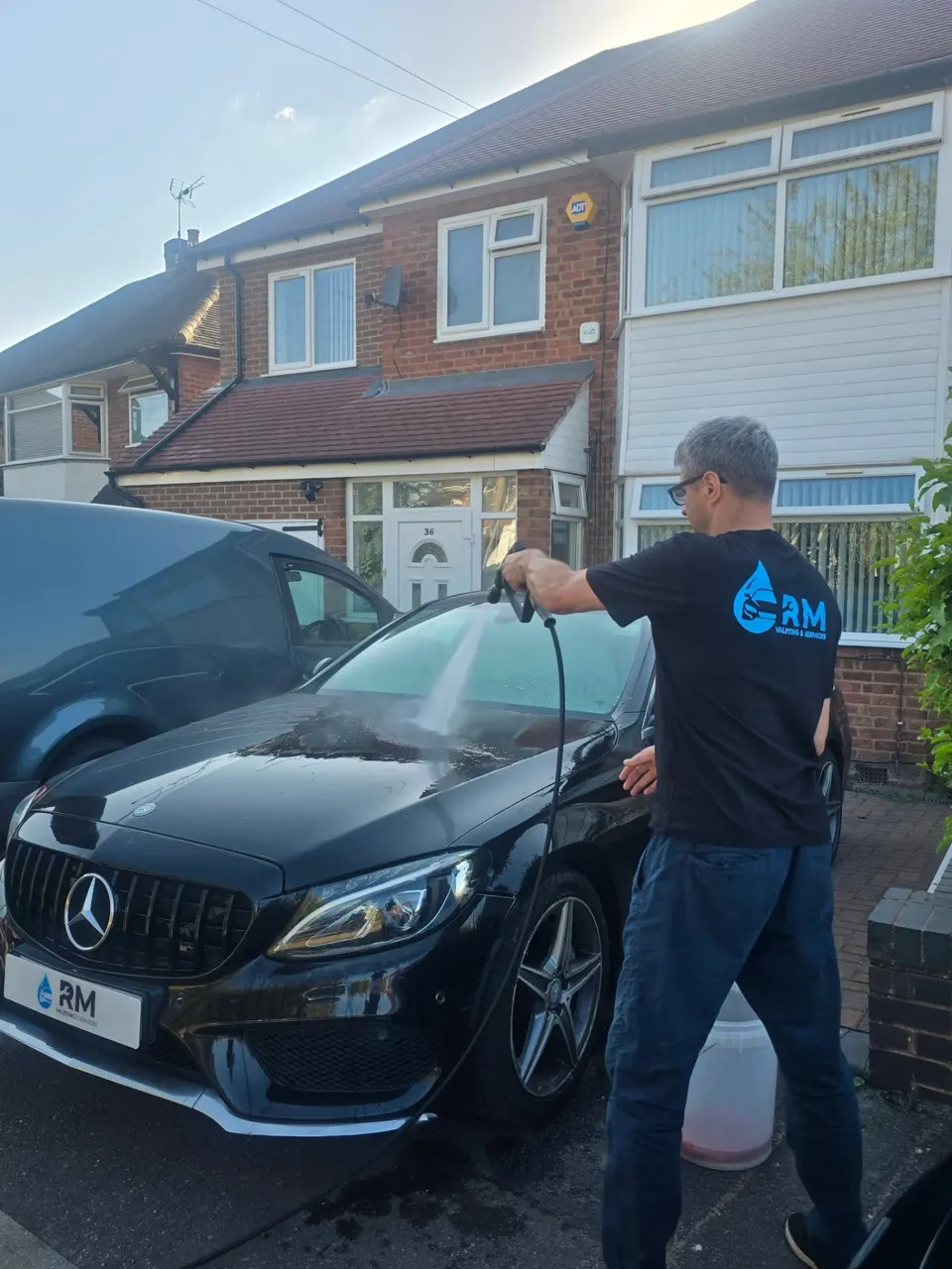 Riyaz rinsing the black Mercedes C220 during a Gold valet
