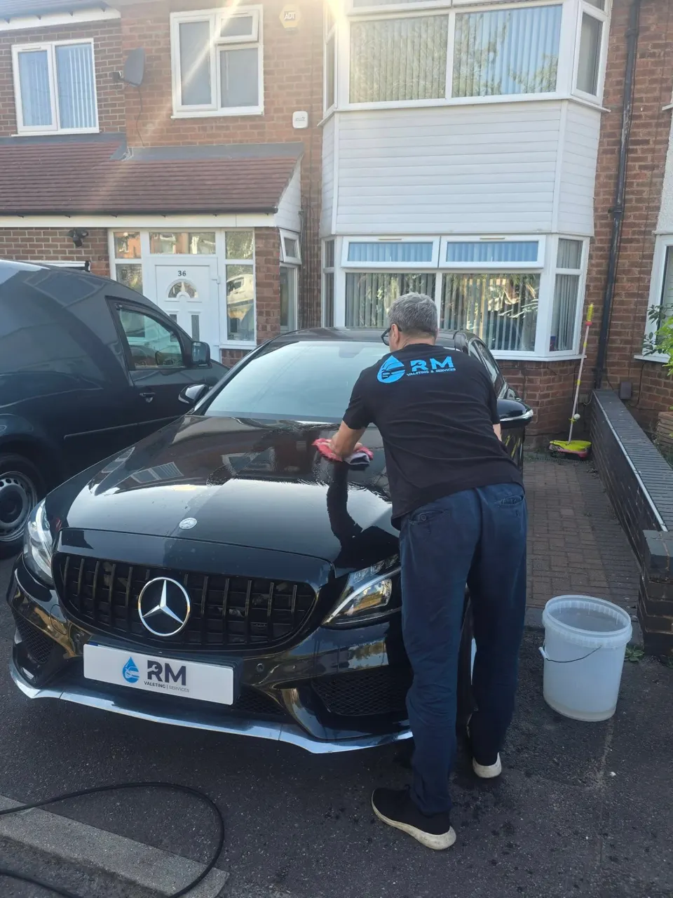 Riyaz drying the bonnet of the black Mercedes C220 after the valet
